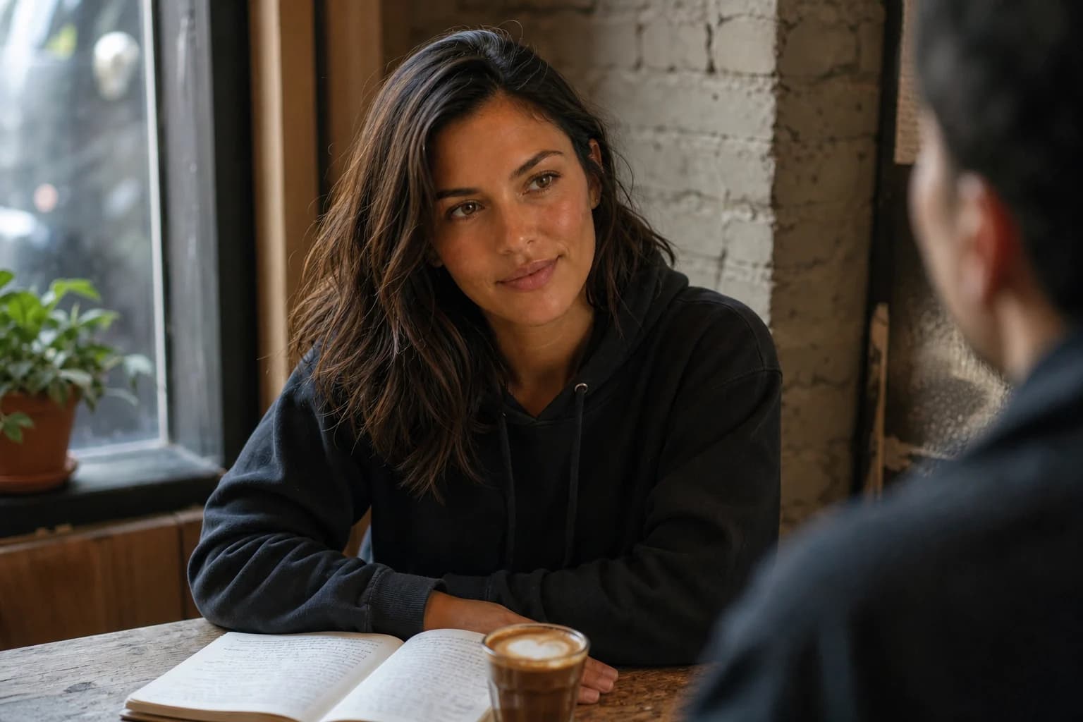 Eliza at a neighborhood coffee-shop table with her notebook and cortado